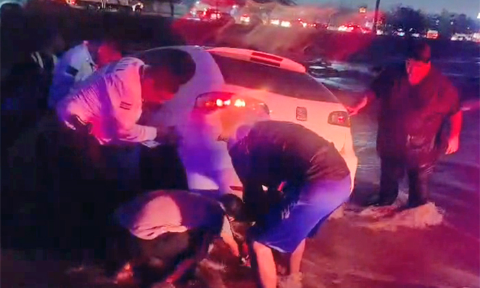 Rescatan a dos personas de auto arrastrado por arroyo